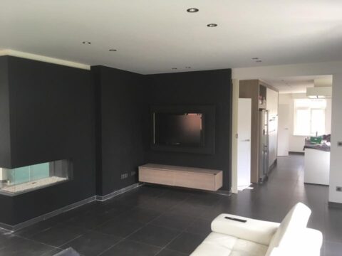 Living met donkere accentwanden rond haard en tv
