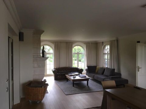Schilderwerken en raamdecoratie in een living